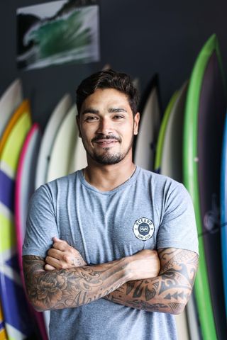 身穿灰色衬衫的男子微笑着站着