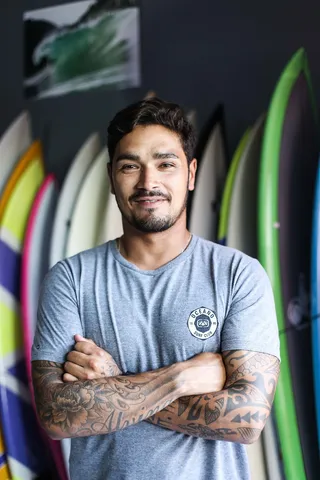 身穿灰色衬衫的男子微笑着站着