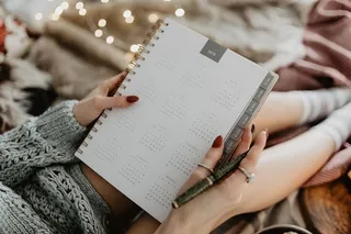 躺在床上的笔记本上写东西，里面有咖啡、蜡烛和姜饼