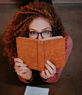 拿着书躺在地板上的女人