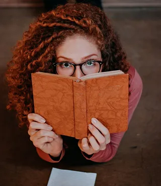 拿着书躺在地板上的女人