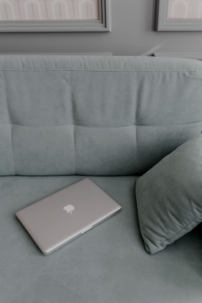 躺在薄荷沙发上的MacBook笔记本电脑