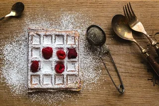 早餐华夫饼配新鲜覆盆子和糖粉