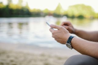 年轻人在海滩上用手机