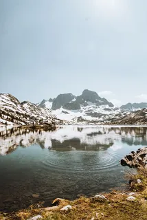 白天被白雪覆盖的群山环绕的水体 白天被白雪覆盖的群山环绕的水体