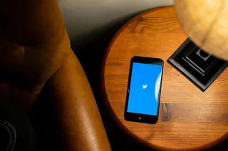 打开棕色木桌上的黑色iPhone