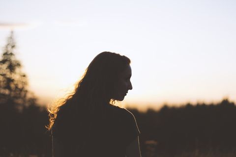 日落时女人和树的剪影