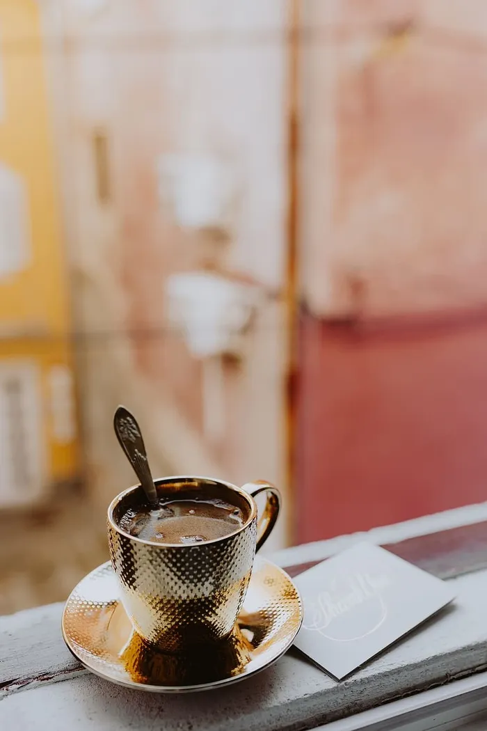 在窗前的金杯里喝咖啡