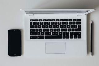 带智能手机和耳机的白色笔记本电脑