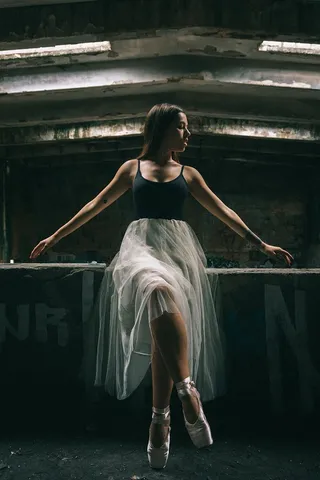 身着黑白服装的芭蕾舞演员坐在墙上的照片