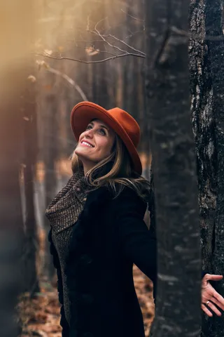 女人张开双臂，被树木环绕