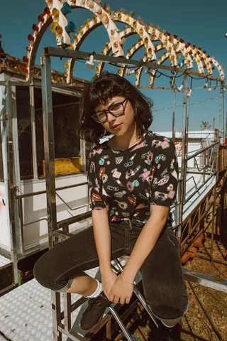 坐在室外灰色金属框架上的女人