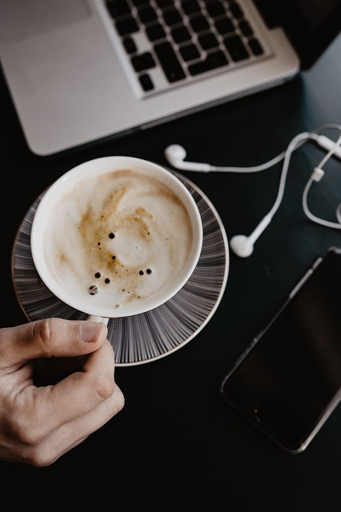 男性用笔记本电脑和一杯咖啡工作