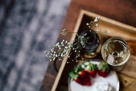 木托盘上的草莓、奶油和白葡萄酒