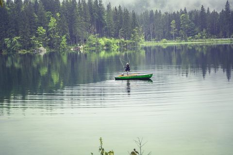 绿色船上的人在水体上捕鱼