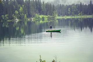 绿色船上的人在水体上捕鱼