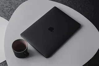 桌上马克杯旁的MacBook Pro