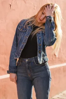 女人抱着她的头穿着蓝色牛仔夹克