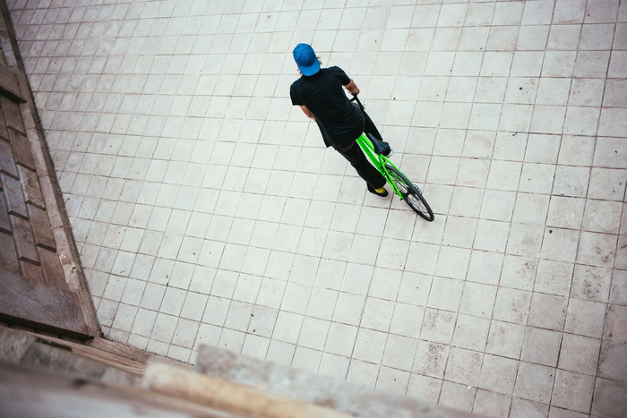 一位戴着蓝色帽子的年轻白人男性自行车手在街上停了下来