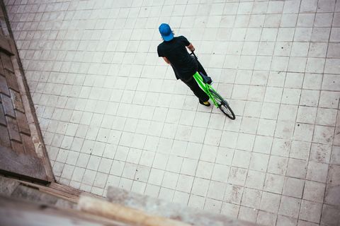 一位戴着蓝色帽子的年轻白人男性自行车手在街上停了下来