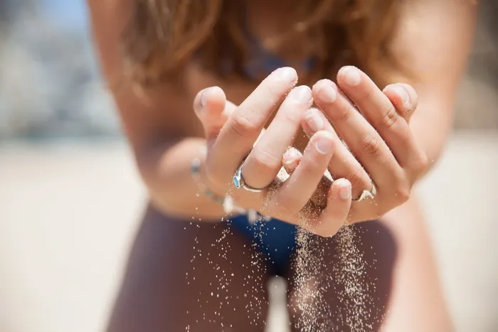 戴着银色戒指拿着沙子的女人