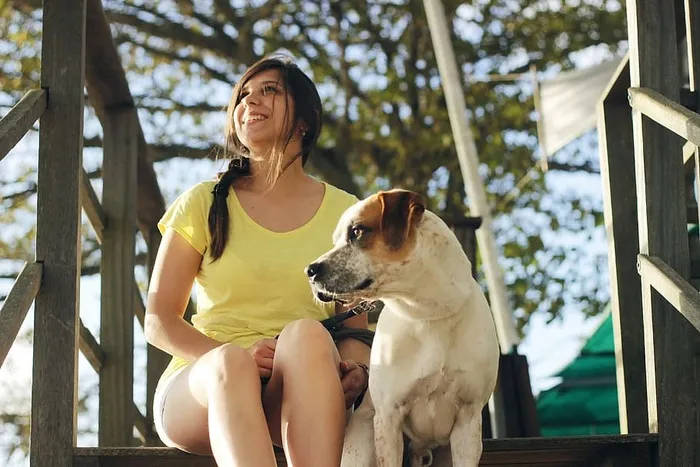 坐在杰克·拉塞尔猎犬旁边的女人