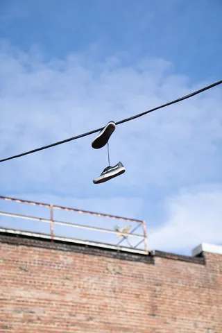 挂在电缆上的鞋子的低角度摄影