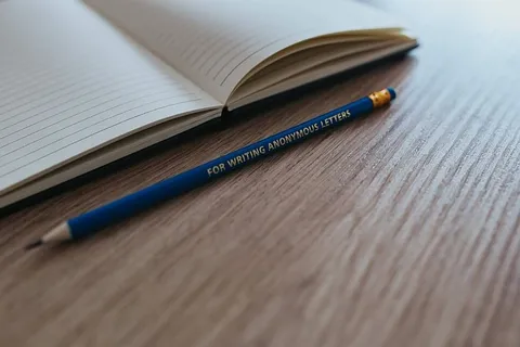 木制书桌上有彩色铅笔的笔记本