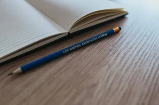 木制书桌上有彩色铅笔的笔记本