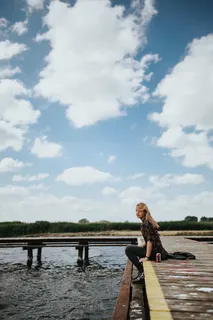 湖边一个木码头上美丽的金发女人