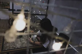 身穿白衬衫坐在桌旁椅子上的女人