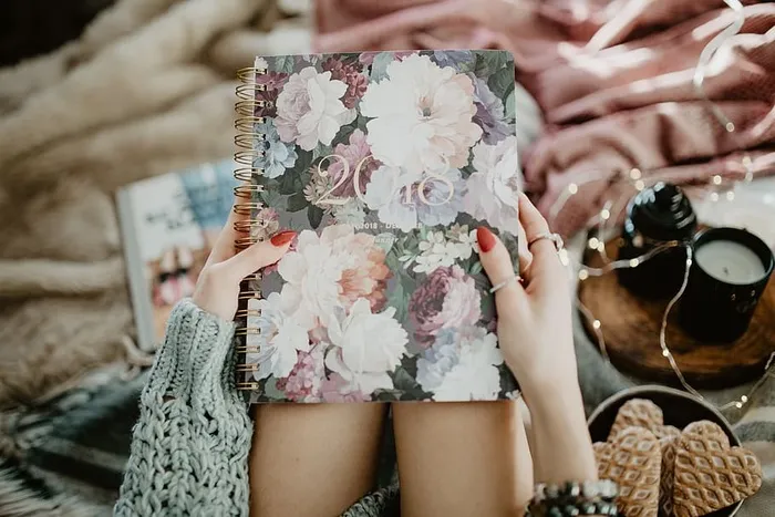 躺在床上的笔记本上写东西，里面有咖啡、蜡烛和姜饼