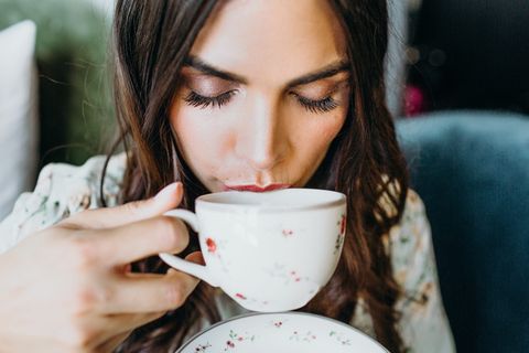 女人用茶杯喝酒