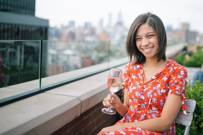 一个女人坐在椅子上拿着酒杯的照片