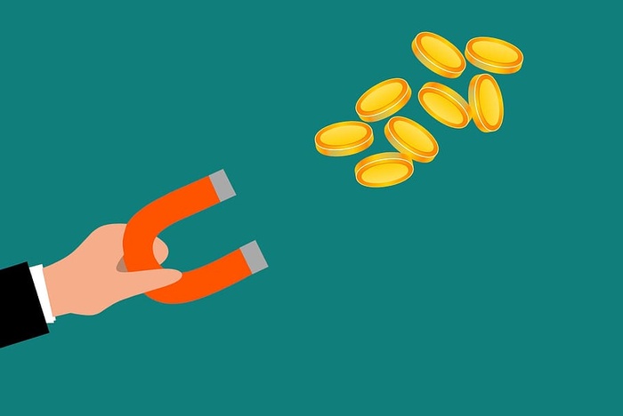 磁铁吸引金属硬币的插图。