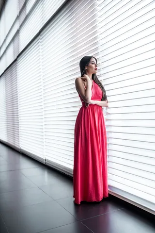 站在窗边的粉红色连衣裙的女人