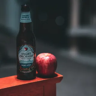 红苹果旁边的愤怒果园硬苹果酒瓶 红苹果旁边的愤怒果园硬苹果酒瓶