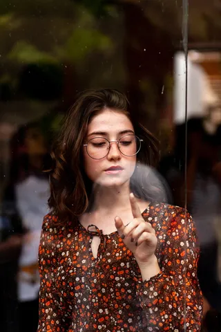 一位戴黑框眼镜的妇女正在触摸眼镜