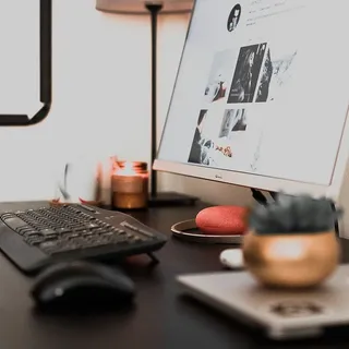 黑色木桌上的白色平板电脑显示器