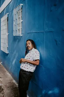 靠在窗户附近蓝色墙壁上的男子 靠在窗户附近蓝色墙壁上的男子