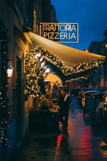 一名男子站在Trattoria Pizzeria店外 一名男子站在Trattoria Pizzeria店外