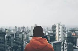 穿着橙色连帽衫盯着建筑物的人