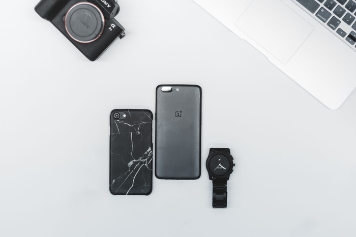 2017年后的黑色iPhone旁边是白色表面的黑色手表