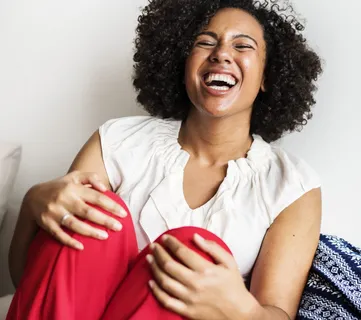 穿着白色无袖上衣和红色下装的女人在笑