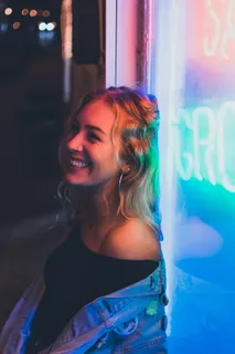 靠在霓虹灯标牌上的女人 靠在霓虹灯标牌上的女人