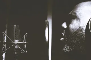 男子在流行滤光片和冷凝麦克风附近唱歌