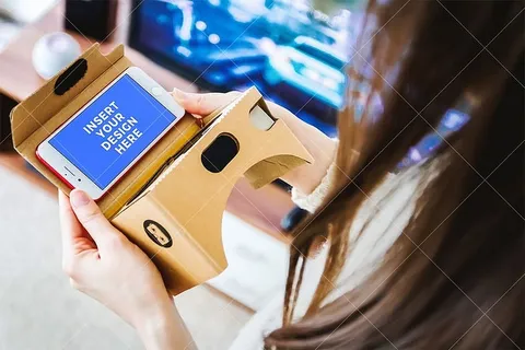 PSD模型。女孩用她的智能手机进行虚拟现实(VR)。硬纸板 PSD模型。女孩用她的智能手机进行虚拟现实(VR)。硬纸板