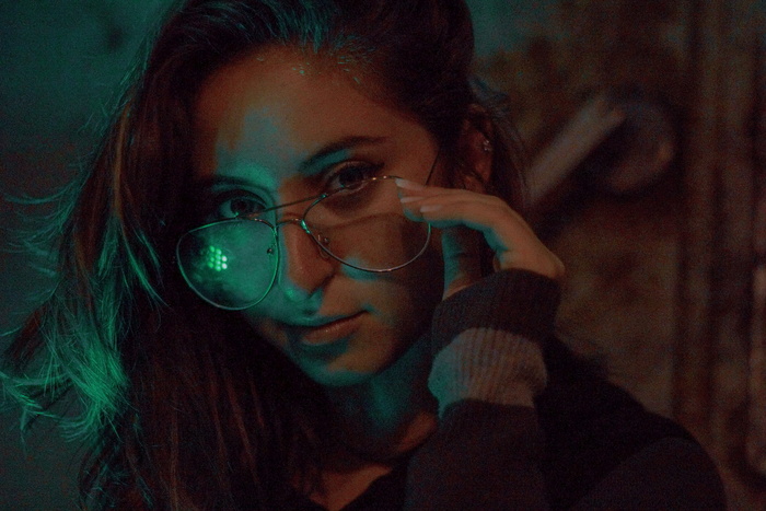 举着灰框眼镜的女人的特写照片