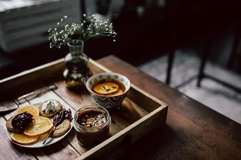 酒店早餐的客房服务托盘：饼干、果酱、巧克力慕斯、橘子水果、茶