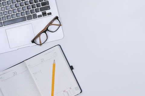 带日记和笔记本电脑的白色工作台